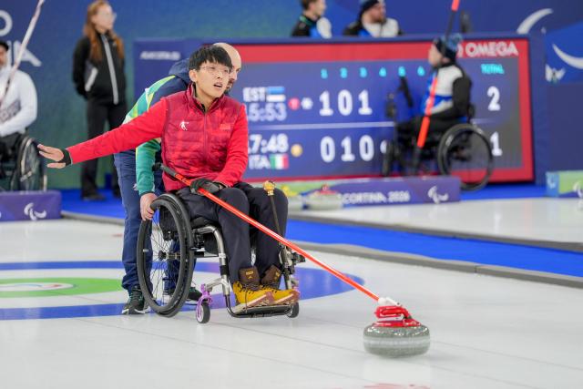 (260305) -- CORTINA D'AMPEZZO, March 5, 2026 (Xinhua) -- Yang Jinqiao of China competes during the wheelchair curling mixed doubles round robin session 2 match between China and Latvia at the Milan-Cortina 2026 Paralympic Winter Games in Cortina D'ampezzo, Italy, March 5, 2026. (Xinhua/Lian Zhen)