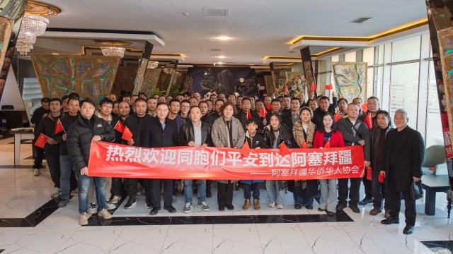(260305) -- BAKU, March 5, 2026 (Xinhua) -- Chinese Ambassador to Azerbaijan Lu Mei (C, front) poses for a group photo with Chinese nationals evacuated from Iran in a hotel lobby in Baku, Azerbaijan, March 3, 2026. TO GO WITH Feature: A taste of home for Chinese evacuees from Iran in Azerbaijan (Xinhua/Chen Junfeng)