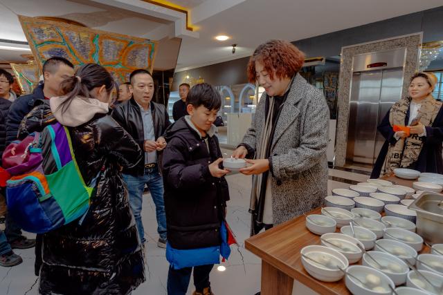 (260305) -- BAKU, March 5, 2026 (Xinhua) -- Chinese Ambassador to Azerbaijan Lu Mei (2nd R) hands a bowl of tangyuan, sweet glutinous rice balls traditionally eaten during the Lantern Festival, to a young Chinese national evacuated from Iran in a hotel lobby in Baku, Azerbaijan, March 3, 2026. TO GO WITH Feature: A taste of home for Chinese evacuees from Iran in Azerbaijan (Xinhua/Chen Junfeng)