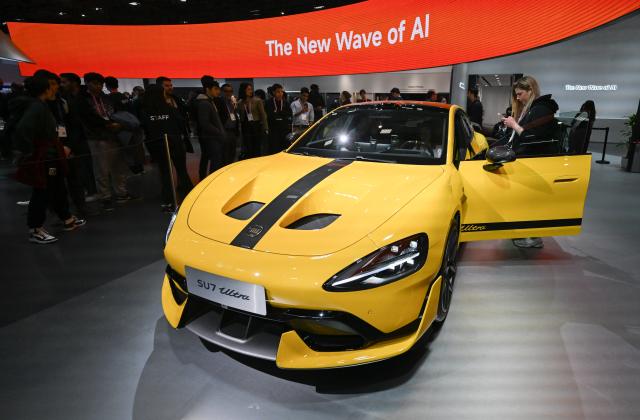(260305) -- BARCELONA, March 5, 2026 (Xinhua) -- People view a vehicle displayed at the booth of Xiaomi during the 2026 Mobile World Congress (MWC) in Barcelona, Spain, March 5, 2026. The 2026 MWC concluded here on Thursday. (Xinhua/Cheng Min)
