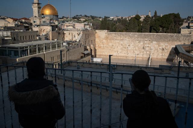 (260305) -- JERUSALEM, March 5, 2026 (Xinhua) -- People pray facing the Western Wall from an elevated platform, in Jerusalem's Old City, March 5, 2026. Israeli police tighten security across Jerusalem's Old City, closing the Western Wall and its plaza amid persisting regional tensions. (Xinhua/Chen Junqing)