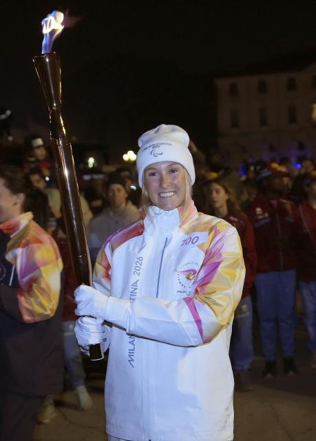 (260306) -- PADUA, March 6, 2026 (Xinhua) -- Torchbearer Francesca Tarantello prepares to pass the torch during the Milan-Cortina 2026 Paralympic Winter Games Torch Relay in Padua, Italy, March 5, 2025. (Xinhua/Hou Jun)