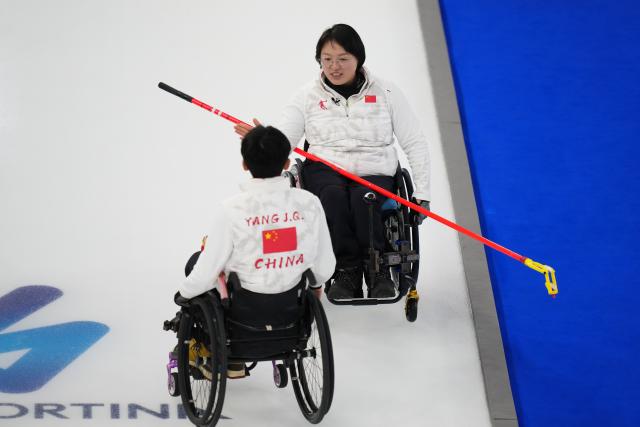 (260306) -- CORTINA D'AMPEZZO, March 6, 2026 (Xinhua) -- Wang Meng of China celebrates with teammate Yang Jinqiao (L) during the wheelchair curling mixed doubles round robin session 3 match between China and Italy at the Milan-Cortina 2026 Paralympic Winter Games in Cortina D'ampezzo, Italy, March 5, 2026. (Xinhua/Lian Yi)