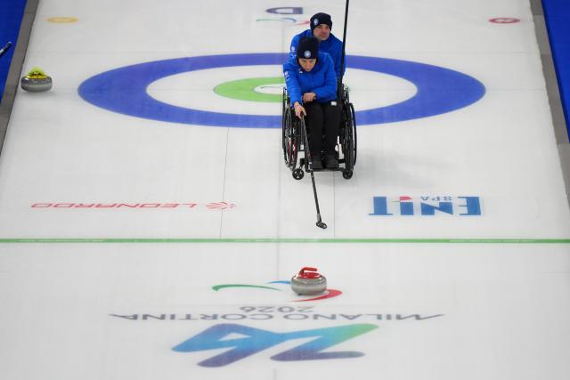 (260306) -- CORTINA D'AMPEZZO, March 6, 2026 (Xinhua) -- Orietta Berto (front) of Italy competes during the wheelchair curling mixed doubles round robin session 3 match between China and Italy at the Milan-Cortina 2026 Paralympic Winter Games in Cortina D'ampezzo, Italy, March 5, 2026. (Xinhua/Lian Yi)