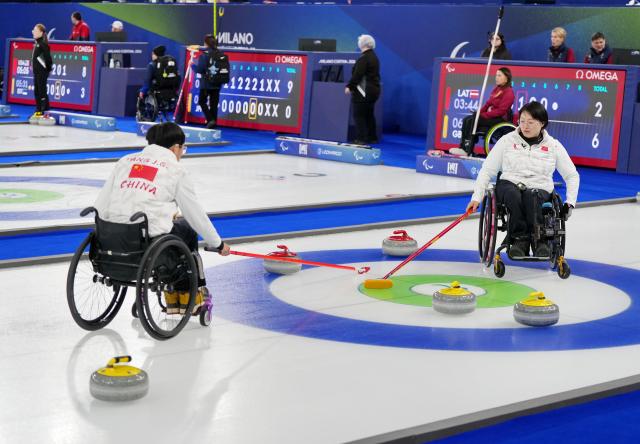 (260306) -- CORTINA D'AMPEZZO, March 6, 2026 (Xinhua) -- Yang Jinqiao (L) and Wang Meng of China compete during the wheelchair curling mixed doubles round robin session 3 match between China and Italy at the Milan-Cortina 2026 Paralympic Winter Games in Cortina D'ampezzo, Italy, March 5, 2026. (Xinhua/Mou Yu)