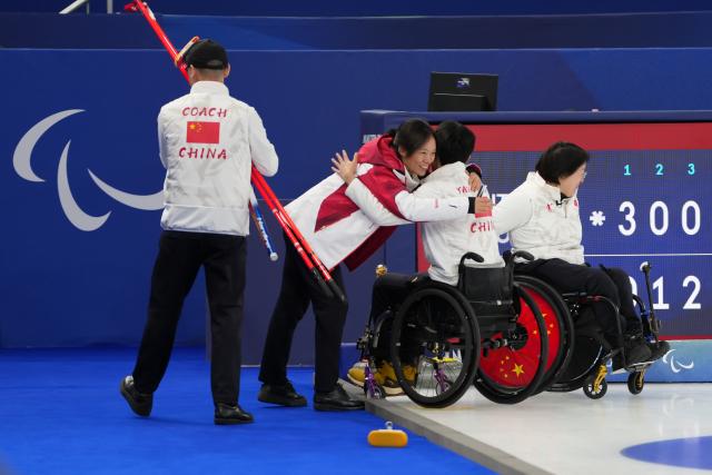 (260306) -- CORTINA D'AMPEZZO, March 6, 2026 (Xinhua) -- Yang Jinqiao (2nd R) of China celebrates after the wheelchair curling mixed doubles round robin session 3 match between China and Italy at the Milan-Cortina 2026 Paralympic Winter Games in Cortina D'ampezzo, Italy, March 5, 2026. (Xinhua/Lian Yi)