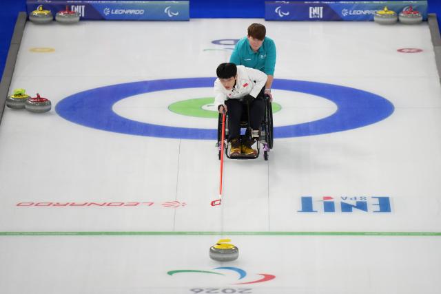 (260306) -- CORTINA D'AMPEZZO, March 6, 2026 (Xinhua) -- Yang Jinqiao of China competes during the wheelchair curling mixed doubles round robin session 3 match between China and Italy at the Milan-Cortina 2026 Paralympic Winter Games in Cortina D'ampezzo, Italy, March 5, 2026. (Xinhua/Lian Yi)