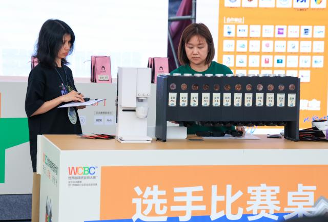(260306) -- JIANGMEN, March 6, 2026 (Xinhua) -- Contestants select coffee beans for blending during a competition held at the 4th Jiangmen Coffee Culture Festival in Jiangmen, south China's Guangdong Province, March 5, 2026. The festival kicked off here on Thursday, gathering more than 330 coffee brands from 13 countries and regions to showcase a full range of products including premium coffee, high-quality coffee raw materials, advanced coffee machines and elegant coffee gear. (Xinhua/Mao Siqian)