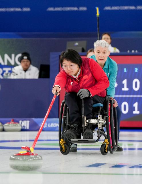 (260306) -- CORTINA D'AMPEZZO, March 6, 2026 (Xinhua) -- Wang Meng (front) of China competes during the wheelchair curling mixed doubles round robin session 4 match between China and South Korea at the Milan-Cortina 2026 Paralympic Winter Games in Cortina D'ampezzo, Italy, March 6, 2026. (Xinhua/Wang Kaiyan)