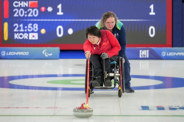 (260306) -- CORTINA D'AMPEZZO, March 6, 2026 (Xinhua) -- Wang Meng (front) of China competes during the wheelchair curling mixed doubles round robin session 4 match between China and South Korea at the Milan-Cortina 2026 Paralympic Winter Games in Cortina D'ampezzo, Italy, March 6, 2026. (Xinhua/Wang Kaiyan)