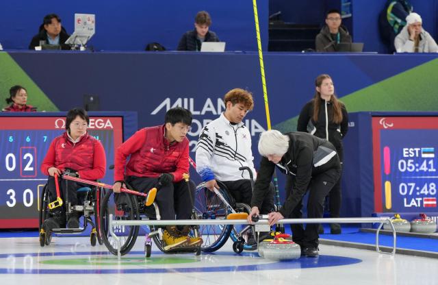 (260306) -- CORTINA D'AMPEZZO, March 6, 2026 (Xinhua) -- Referee check the curlings during the wheelchair curling mixed doubles round robin session 4 match between China and South Korea at the Milan-Cortina 2026 Paralympic Winter Games in Cortina D'ampezzo, Italy, March 6, 2026. (Xinhua/Wang Kaiyan)