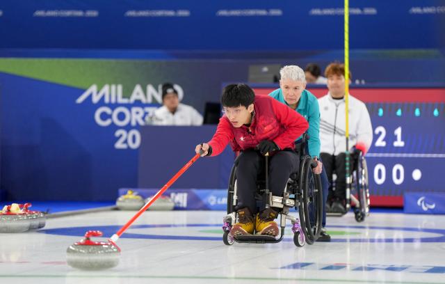 (260306) -- CORTINA D'AMPEZZO, March 6, 2026 (Xinhua) -- Yang Jinqiao (front) of China competes during the wheelchair curling mixed doubles round robin session 4 match between China and South Korea at the Milan-Cortina 2026 Paralympic Winter Games in Cortina D'ampezzo, Italy, March 6, 2026. (Xinhua/Wang Kaiyan)