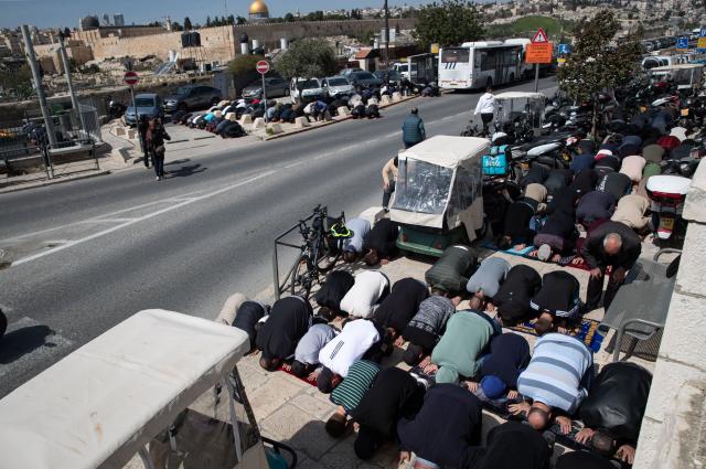 (260306) -- JERUSALEM, March 6, 2026 (Xinhua) -- Palestinians perform Friday prayers outside the Old City of Jerusalem as Israeli police implement extensive security measures, March 6, 2026. (Xinhua/Chen Junqing)