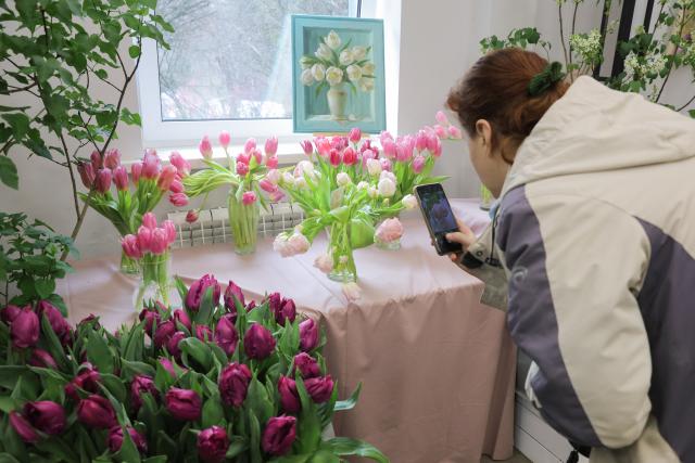 (260306) -- ST. PETERSBURG, March 6, 2026 (Xinhua) -- A woman takes photos of flowers with her mobile phone during a flower show to celebrate the upcoming International Women's Day in St. Petersburg, Russia, March 6, 2026. (Photo by Irina Motina/Xinhua)