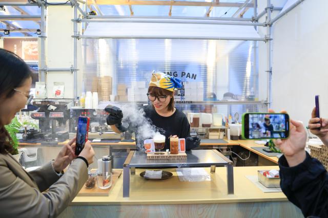 (260307) -- Beijing, March 7, 2026 (Xinhua) -- A staff member of Seng Pan Coffee makes coffee for customers during the 4th Jiangmen Coffee Culture Festival in Jiangmen, south China's Guangdong Province, March 5, 2026. The festival kicked off here on Thursday, gathering more than 330 coffee brands from 13 countries and regions to showcase a full range of products including premium coffee, high-quality coffee raw materials, advanced coffee machines and elegant coffee gear. (Xinhua/Mao Siqian)