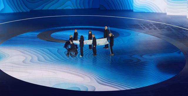 (260307) -- VERONA, March 7, 2026 (Xinhua) -- The Paralympic flag is carried onto the stage during the opening ceremony of Milan-Cortina 2026 Paralympic Winter Games at Verona Olympic Arena in Verona, Italy, March 6, 2026. (Xinhua/Cai Yang)