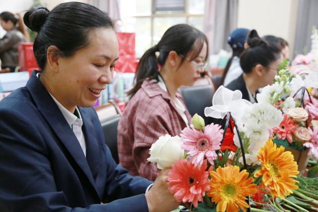 (260307) -- BEIJING, March 7, 2026 (Xinhua) -- Women learn flower arranging at an event celebrating International Women's Day in Mengzi City, southwest China's Yunnan Province, March 5, 2026. Various events were held across China recently to mark International Women's Day. (Photo by Xue Yingying/Xinhua)