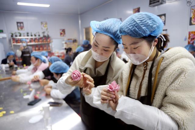 (260307) -- BEIJING, March 7, 2026 (Xinhua) -- Women make dough sculpture at an event celebrating International Women's Day in Lianyungang, east China's Jiangsu Province, March 6, 2026. Various events were held across China recently to mark International Women's Day. (Photo by Wang Chun/Xinhua)