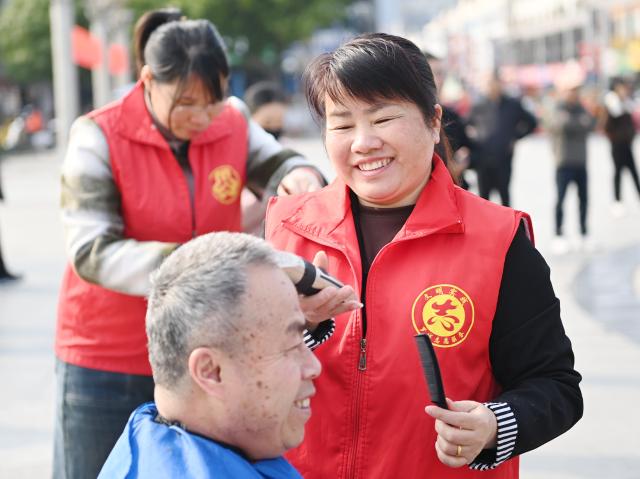 (260307) -- BEIJING, March 7, 2026 (Xinhua) -- Female volunteers offer free haircuts to the citizens in Luocheng Mulao Autonomous County, Hechi City, south China's Guangxi Zhuang Autonomous Region, March 6, 2026. Various events were held across China recently to mark International Women's Day. (Photo by Meng Zengshi/Xinhua)