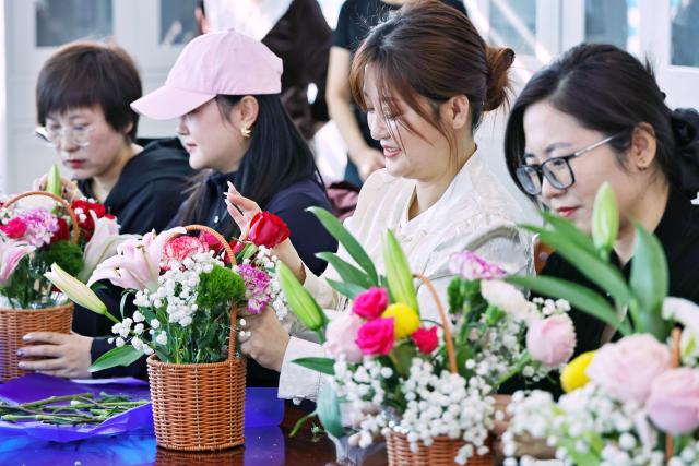 (260307) -- BEIJING, March 7, 2026 (Xinhua) -- Women attend a flower arrangement competition held by a community in Tongjiang City, northeast China's Heilongjiang Province, March 6, 2026. Various events were held across China recently to mark International Women's Day. (Photo by Liu Wanping/Xinhua)