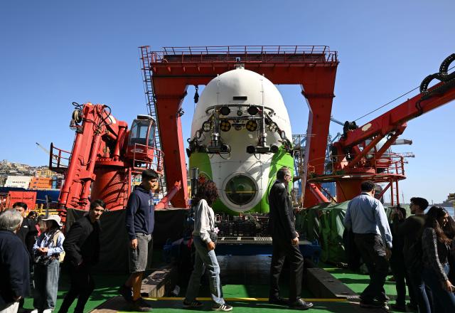 (260307) -- VALPARAISO, March 7, 2026 (Xinhua) -- People look at the deep-sea manned submersible Fendouzhe onbroad the research ship Tansuo-1 at the port of Valparaiso, Chile, March 5, 2026. The closing reception of the Joint China-Chile Atacama Trench Expedition was held here on Thursday. (Photo by Jorge Villegas/Xinhua)