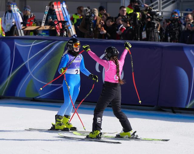(260307) -- CORTINA D'AMPEZZO, March 7, 2026 (Xinhua) -- Martina Vozza (L) of Italy reacts with her guide after her run during para alpine skiing women's downhill vision impaired match at the Milan-Cortina 2026 Paralympic Winter Games in Cortina D'ampezzo, Italy, March 7, 2026. (Xinhua/Wang Kaiyan)