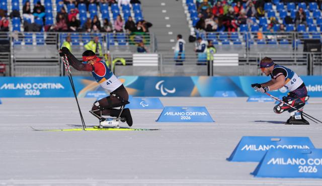 (260307) -- TESERO, March 7, 2026 (Xinhua) -- Wang Tao (L) of China and Scott Meenagh of Britain compete during the men's sprint sitting final of para biathon at the Milan-Cortina 2026 Paralympic Winter Games in Tesero, Italy, March 7, 2026. (Xinhua/Cai Yang)