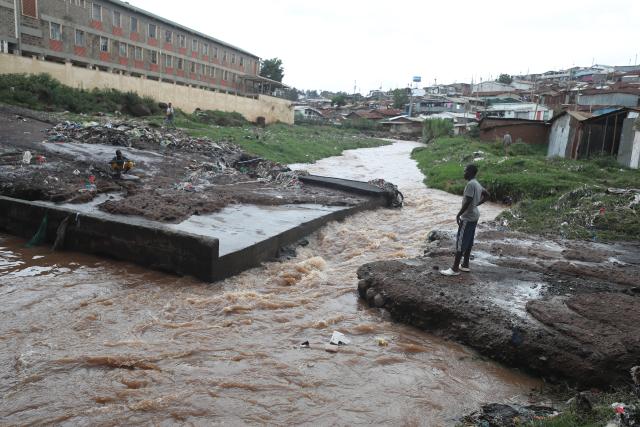 (260307) -- NAIROBI, March 7, 2026 (Xinhua) -- A boy looks at a swollen river after a heavy rain in Kibera of Nairobi, Kenya, on March 7, 2026. The death toll from heavy overnight rainfall that triggered severe flooding across several parts of the Kenyan capital, Nairobi, has risen to 23 as rescue teams continue searching for survivors, police confirmed on Saturday. (Photo by Henry Naminde/Xinhua)