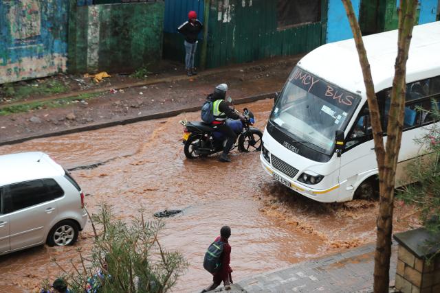 (260307) -- NAIROBI, March 7, 2026 (Xinhua) -- Vehicles move on a flooded road after a heavy rain in Kibera of Nairobi, Kenya, on March 7, 2026. The death toll from heavy overnight rainfall that triggered severe flooding across several parts of the Kenyan capital, Nairobi, has risen to 23 as rescue teams continue searching for survivors, police confirmed on Saturday. (Photo by Henry Naminde/Xinhua)