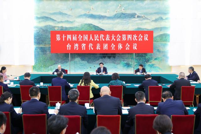 (260307) -- BEIJING, March 7, 2026 (Xinhua) -- Wang Huning, a member of the Standing Committee of the Political Bureau of the Communist Party of China (CPC) Central Committee and chairman of the Chinese People's Political Consultative Conference (CPPCC) National Committee, takes part in a group deliberation with National People's Congress (NPC) deputies from the Taiwan delegation at the fourth session of the 14th National People's Congress in Beijing, capital of China, March 7, 2026. (Xinhua/Liu Bin)