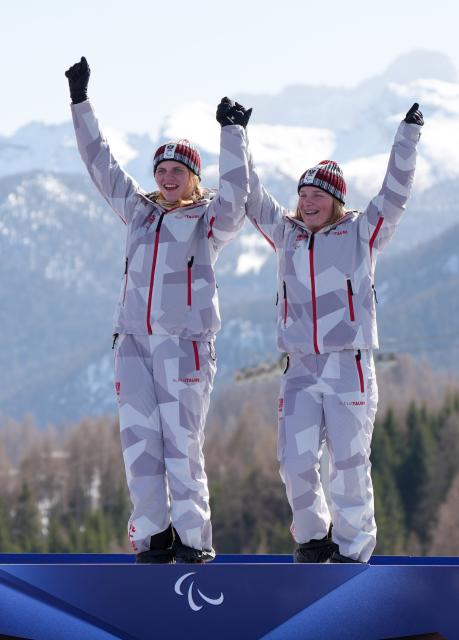(260307) -- CORTINA D'AMPEZZO, March 7, 2026 (Xinhua) -- Veronika Aigner (L) of Austria celebrates with her guide during the awarding ceremony for para alpine skiing women's downhill vision impaired match at the Milan-Cortina 2026 Paralympic Winter Games in Cortina D'ampezzo, Italy, March 7, 2026. (Xinhua/Wang Kaiyan)