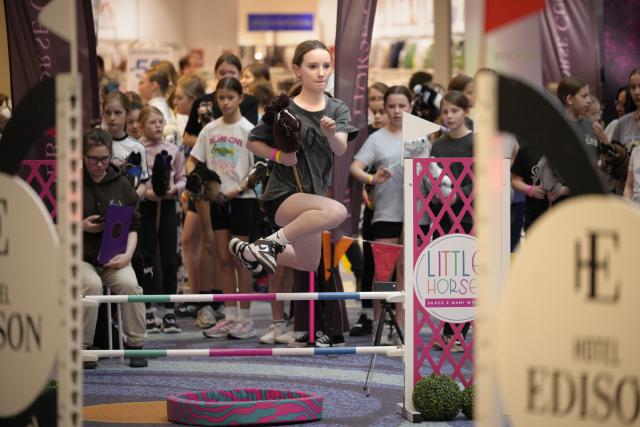 (260308) -- WARSAW, March 8, 2026 (Xinhua) -- A girl jumps over an obstacle during a hobby horsing competition in Warsaw, Poland on March 7, 2026.
  Hobby horsing is a growing sport in Europe in which participants perform movements similar to equestrian jumping or dressage using stick horses. The sport originated in Finland and is particularly popular among young people. (Photo by Jaap Arriens/Xinhua)