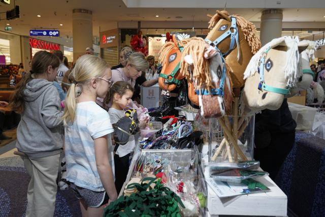 (260308) -- WARSAW, March 8, 2026 (Xinhua) -- Children look at hobby horses displayed at a booth during a hobby horsing competition in Warsaw, Poland on March 7, 2026.
  Hobby horsing is a growing sport in Europe in which participants perform movements similar to equestrian jumping or dressage using stick horses. The sport originated in Finland and is particularly popular among young people. (Photo by Jaap Arriens/Xinhua)