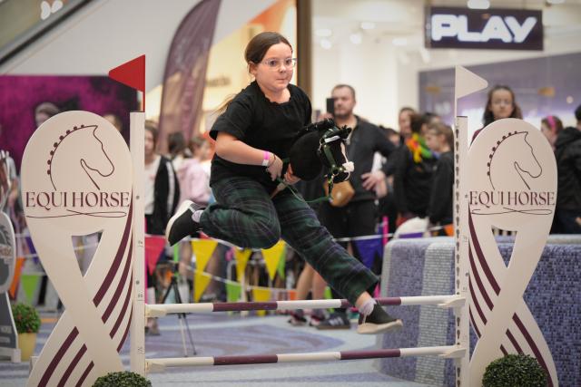 (260308) -- WARSAW, March 8, 2026 (Xinhua) -- A girl jumps over an obstacle during a hobby horsing competition in Warsaw, Poland on March 7, 2026.
  Hobby horsing is a growing sport in Europe in which participants perform movements similar to equestrian jumping or dressage using stick horses. The sport originated in Finland and is particularly popular among young people. (Photo by Jaap Arriens/Xinhua)