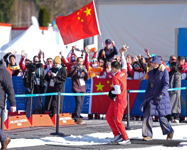 (260308) -- TESERO, March 8, 2026 (Xinhua) -- Gold medalist Cai Jiayun (L) of China waves after the awarding ceremony for the para biathlon men's sprint at the Milan-Cortina 2026 Paralympic Winter Games in Tesero, Italy, March 7, 2026. (Xinhua/Hou Zhaokang)