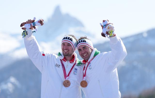(260308) -- CORTINA D'AMPEZZO, March 8, 2026 (Xinhua) -- Bronze medalist Giacomo Bertagnolli (L) of Italy celebrates with his guide Andrea Ravelli during the awarding ceremony for the para alpine skiing men's downhill vision impaired match at the Milan-Cortina 2026 Paralympic Winter Games in Cortina D'ampezzo, Italy, March 7, 2026. (Xinhua/Wang Kaiyan)