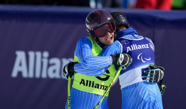 (260308) -- CORTINA D'AMPEZZO, March 8, 2026 (Xinhua) -- Giacomo Bertagnolli (R) of Italy hugs his guide Andrea Ravelli during the para alpine skiing men's downhill vision impaired match at the Milan-Cortina 2026 Paralympic Winter Games in Cortina D'ampezzo, Italy, March 7, 2026. (Xinhua/Wang Kaiyan)