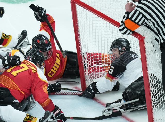 (260308) -- MILAN, March 8, 2026 (Xinhua) -- China's Shen Yifeng (L) and Chen Hongyu (C) vie with Germany's Hugo Raedler during the Para Ice Hockey preliminary round Group A match between China and Germany at the Milan-Cortina 2026 Paralympic Winter Games in Milan, Italy, March 7, 2026. (Xinhua/Li Jing)