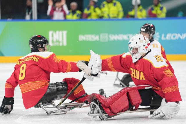 (260308) -- MILAN, March 8, 2026 (Xinhua) -- China's Wang Zhidong (L) and Ji Yanzhao celebrate a goal during the Para Ice Hockey preliminary round Group A match between China and Germany at the Milan-Cortina 2026 Paralympic Winter Games in Milan, Italy, March 7, 2026. (Xinhua/Li Jing)