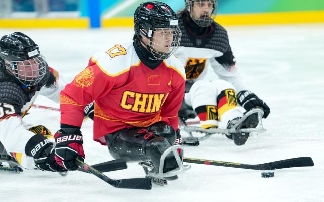 (260308) -- MILAN, March 8, 2026 (Xinhua) -- China's Shen Yifeng shoots during the Para Ice Hockey preliminary round Group A match between China and Germany at the Milan-Cortina 2026 Paralympic Winter Games in Milan, Italy, March 7, 2026. (Xinhua/Li Jing)