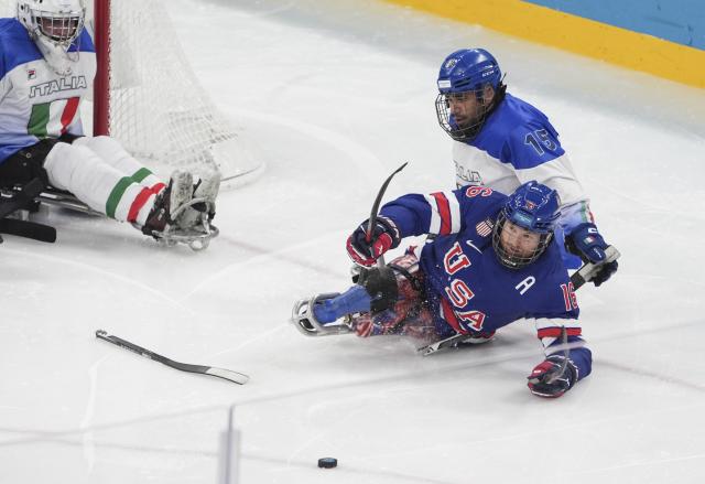 (260308) -- MILAN, March 8, 2026 (Xinhua) -- Declan Farmer (front) of the United States battles for the puck with Nikko Landeros (back R) of Italy during the Para Ice Hockey Preliminary Round Group A match between the United States and Italy at the Milan-Cortina 2026 Paralympic Winter Games in Milan, Italy, March 7, 2026. (Xinhua/Hou Jun)