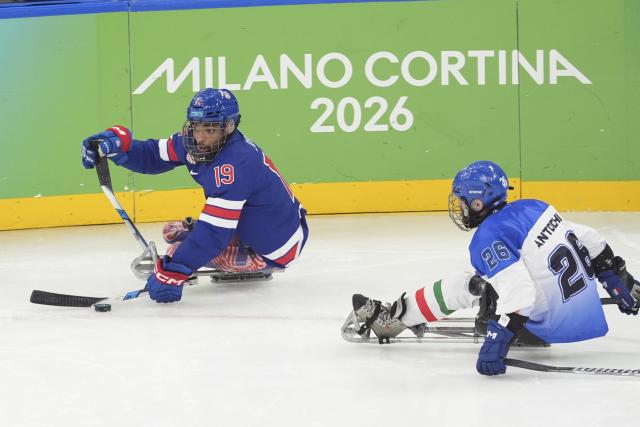 (260308) -- MILAN, March 8, 2026 (Xinhua) -- Malik Jones (L) of the United States controls the puck during the Para Ice Hockey Preliminary Round Group A match between the United States and Italy at the Milan-Cortina 2026 Paralympic Winter Games in Milan, Italy, March 7, 2026. (Xinhua/Hou Jun)
