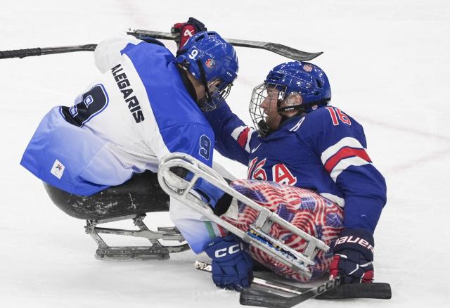 (260308) -- MILAN, March 8, 2026 (Xinhua) -- Declan Farmer (R) of the United States fights with Sandro Kalegaris of Italy during the Para Ice Hockey Preliminary Round Group A match between the United States and Italy at the Milan-Cortina 2026 Paralympic Winter Games in Milan, Italy, March 7, 2026. (Xinhua/Hou Jun)