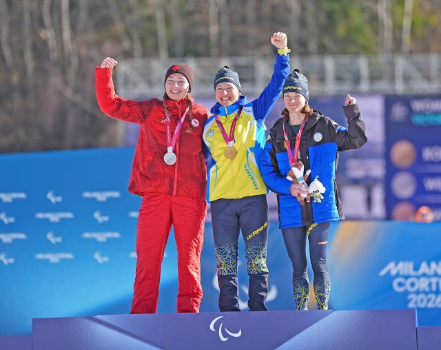 (260308) -- TESERO, March 8, 2026 (Xinhua) -- Gold medalist Oleksandra Kononova (C) of Ukraine celebrates on the podium alongside silver medalist Natalie Wilkie (L) of Canada and bronze medalist Liudmyla Liashenko of Ukraine during the awarding ceremony for the para biathlon women's sprint standing at the Milan-Cortina 2026 Paralympic Winter Games in Tesero, Italy, March 7, 2026. (Xinhua/Hou Zhaokang)