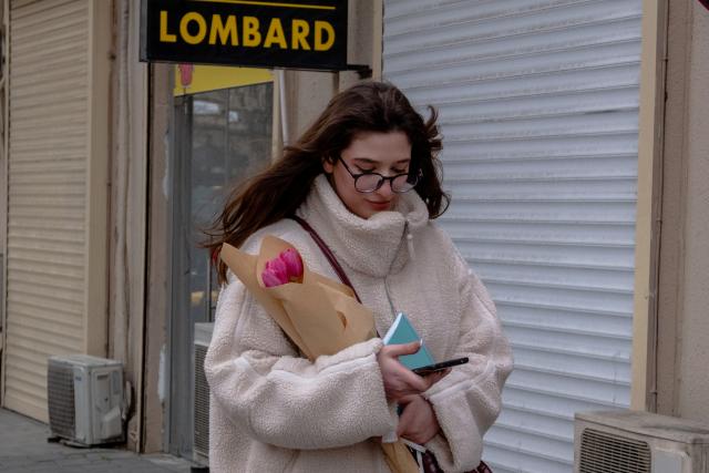 (260308) -- BAKU, March 8, 2026 (Xinhua) -- A woman walks with bunches of flowers in Baku, Azerbaijan, March 7, 2026. Sunday marks International Women's Day. (Xinhua/Chen Junfeng)