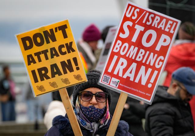 (260308) -- VANCOUVER, March 8, 2026 (Xinhua) -- A demonstrator holds placards during a rally against U.S.-Israeli attacks on Iran, in Vancouver, British Columbia, Canada, March 7, 2026. (Photo by Liang Sen/Xinhua)