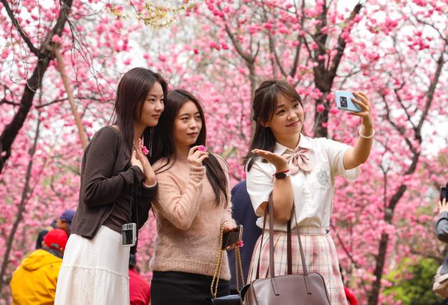 (260308) -- BEIJING, March 8, 2026 (Xinhua) -- Tourists pose for photos at a zoo in Kunming, southwest China's Yunnan Province, March 7, 2026. (Photo by Zheng Yi/Xinhua)