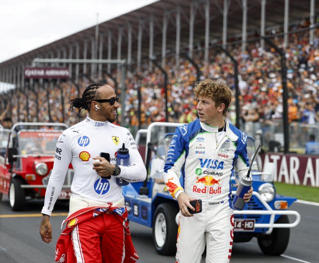 (260308) -- MELBOURNE, March 8, 2026 (Xinhua) -- Ferrari's Lewis Hamilton (L) of Britain and Racing Bull's Liam Lawson of New Zealand communicate after the Drivers' Parade before the Formula One Australia Grand Prix at Albert Park in Melbourne, Australia, March 8, 2026. (Xinhua/Ma Ping)