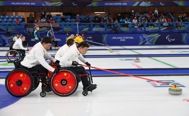 (260310) -- CORTINA D'AMPEZZO, March 10, 2026 (Xinhua) -- Zhang Mingliang (front R) of China competes during the wheelchair curling mixed team round robin session 6 match between China and Norway at the Milan-Cortina 2026 Paralympic Winter Games in Cortina D'ampezzo, Italy, March 9, 2026. (Xinhua/Wang Kaiyan)