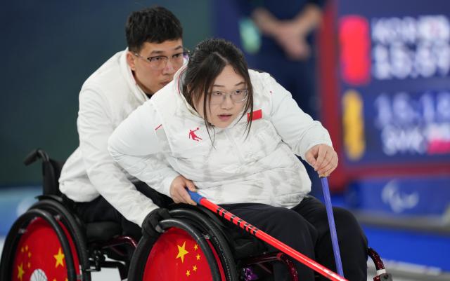 (260310) -- CORTINA D'AMPEZZO, March 10, 2026 (Xinhua) -- Li Nana (R) of China competes during the wheelchair curling mixed team round robin session 6 match between China and Norway at the Milan-Cortina 2026 Paralympic Winter Games in Cortina D'ampezzo, Italy, March 9, 2026. (Xinhua/Wang Kaiyan)